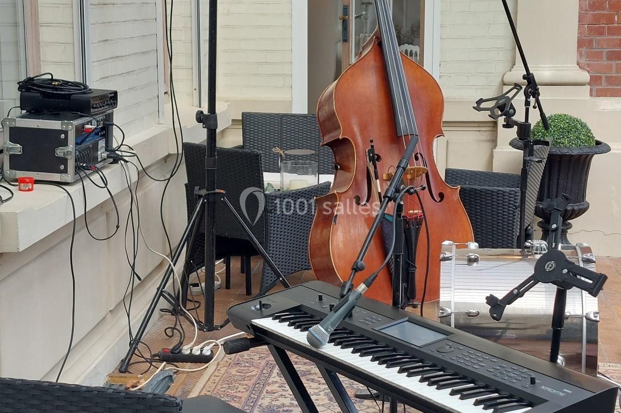 Instruments de musique installés en extérieur avec un clavier, une contrebasse, des micros et des enceintes.