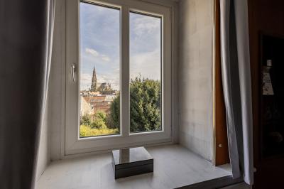 Douche moderne avec paroi en verre, entourée de carreaux dorés brillants formant un motif mosaïque.
