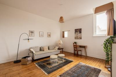 Douche moderne avec paroi en verre, entourée de carreaux dorés brillants formant un motif mosaïque.