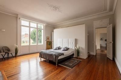 Douche moderne avec paroi en verre, entourée de carreaux dorés brillants formant un motif mosaïque.