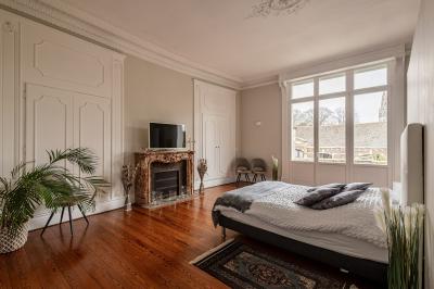 Douche moderne avec paroi en verre, entourée de carreaux dorés brillants formant un motif mosaïque.