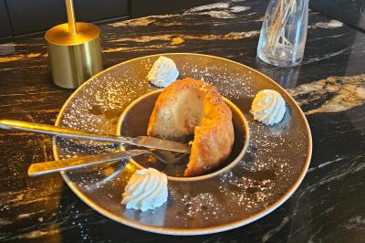 Douche moderne avec paroi en verre, entourée de carreaux dorés brillants formant un motif mosaïque.