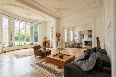 Douche moderne avec paroi en verre, entourée de carreaux dorés brillants formant un motif mosaïque.