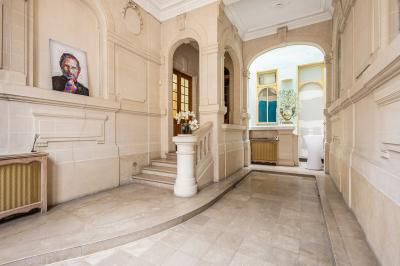 Douche moderne avec paroi en verre, entourée de carreaux dorés brillants formant un motif mosaïque.