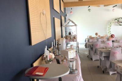 Un homme et une femme souriants derrière un comptoir en bois, avec des étagères de boissons en arrière-plan.