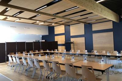 Kitchenette équipée avec évier, plaques de cuisson, bouilloire et vue sur une chambre avec lit double et parquet.