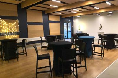 Kitchenette équipée avec évier, plaques de cuisson, bouilloire et vue sur une chambre avec lit double et parquet.