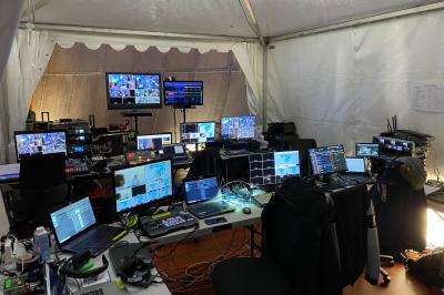 Installation technique avec écrans, projecteurs et équipements audiovisuels dans une salle aux murs clairs.