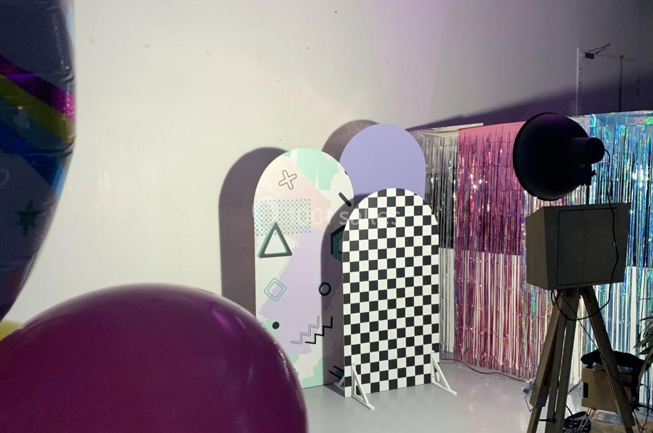 Décor coloré avec panneaux géométriques et rideaux brillants dans un studio éclairé.