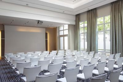 Salle de petit-déjeuner avec buffet varié, tables dressées, éclairage chaleureux et décor moderne en bois sombre.