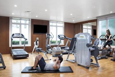 Salle de petit-déjeuner avec buffet varié, tables dressées, éclairage chaleureux et décor moderne en bois sombre.