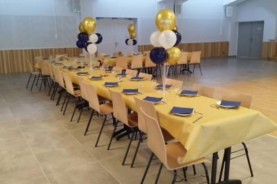 Bâtiment moderne entouré d'espaces verts, avec une aire de jeux pour enfants et un parking à proximité.