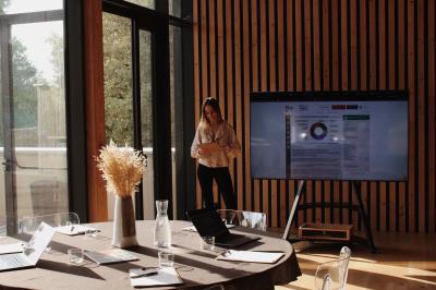 Quatre personnes regardent un coucher de soleil aux teintes orange et violet depuis une terrasse surplombant des vignes.