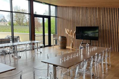Quatre personnes regardent un coucher de soleil aux teintes orange et violet depuis une terrasse surplombant des vignes.