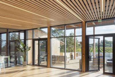 Quatre personnes regardent un coucher de soleil aux teintes orange et violet depuis une terrasse surplombant des vignes.