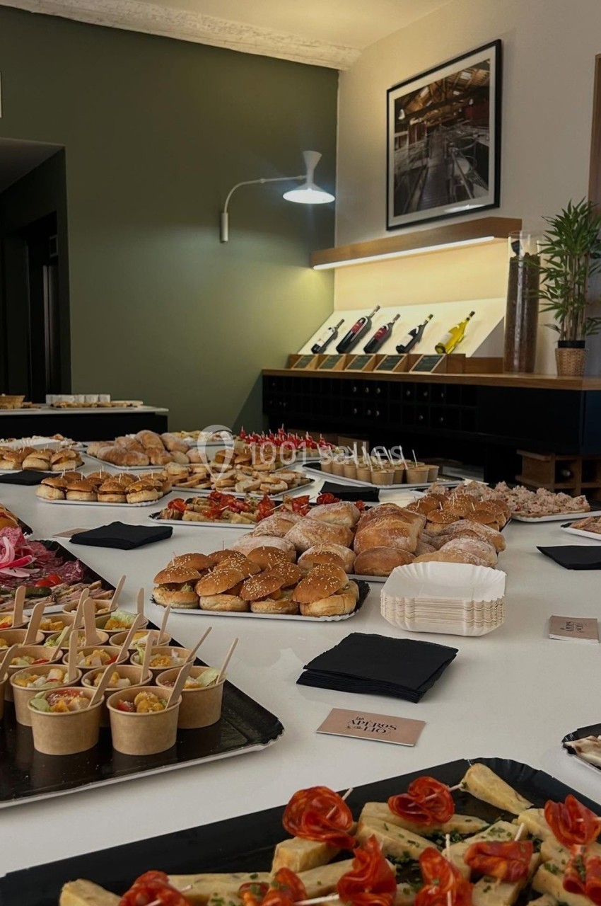 Buffet varié avec sandwichs, verrines, amuse-bouches et viennoiseries disposés sur une grande table blanche.