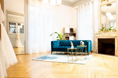 Femme portant une robe de mariée blanche avec un dos ouvert, posant dans un jardin fleuri.