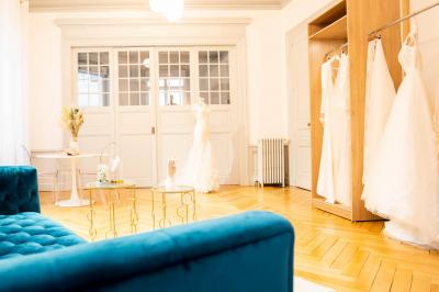 Femme portant une robe de mariée blanche avec un dos ouvert, posant dans un jardin fleuri.