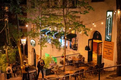 Façade d'un pub irlandais avec enseignes vertes, drapeau irlandais et arbres aux feuilles d'automne.