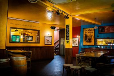 Façade d'un pub irlandais avec enseignes vertes, drapeau irlandais et arbres aux feuilles d'automne.
