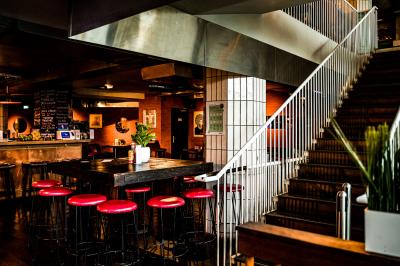 Tableau noir devant un établissement annonçant restauration, happy hour, musique live et club.