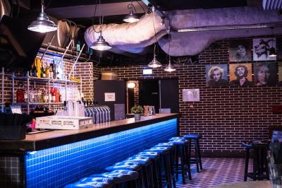 Tableau noir devant un établissement annonçant restauration, happy hour, musique live et club.