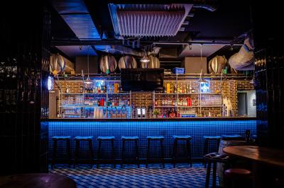 Tableau noir devant un établissement annonçant restauration, happy hour, musique live et club.