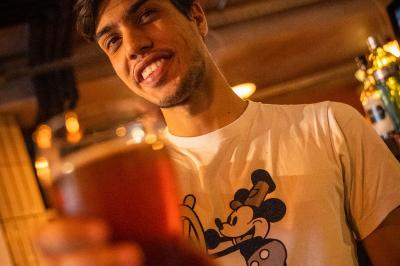 Tableau noir devant un établissement annonçant restauration, happy hour, musique live et club.