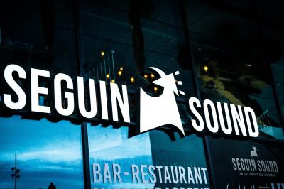 Tableau noir devant un établissement annonçant restauration, happy hour, musique live et club.