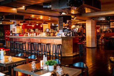 Miniature Location salle Boulogne-Billancourt (Hauts-de-Seine) - Seguin Sound #14 Terrasse extérieure d'un restaurant avec tables, chaises, parasols et végétation, vue à travers des feuillages.