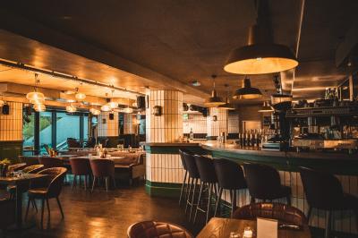 Miniature Location salle Boulogne-Billancourt (Hauts-de-Seine) - Seguin Sound #26 Terrasse extérieure d'un restaurant avec tables, chaises, parasols et végétation, vue à travers des feuillages.