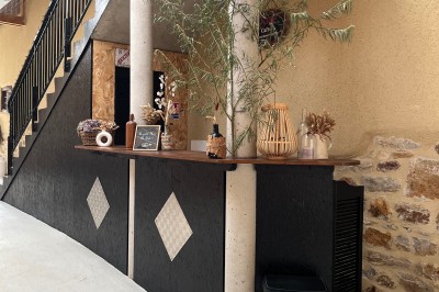 Deux grands arbres bordent une pelouse verdoyante sous un ciel partiellement nuageux.