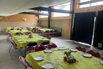 Deux grands arbres bordent une pelouse verdoyante sous un ciel partiellement nuageux.