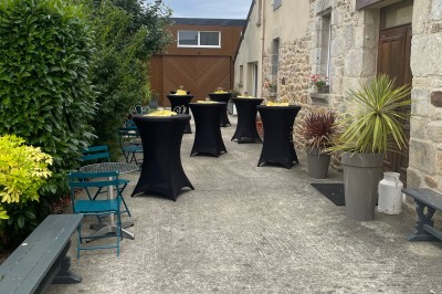Deux grands arbres bordent une pelouse verdoyante sous un ciel partiellement nuageux.