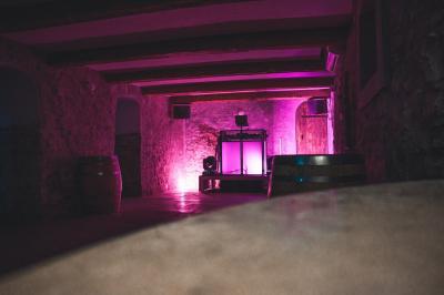 Structure en bois éclairée la nuit, avec des sphères lumineuses blanches posées sur un sol en pierre.