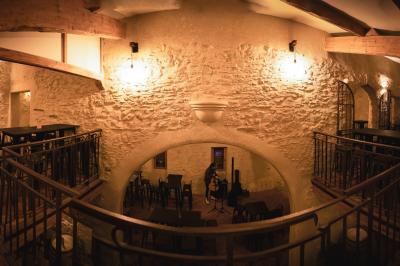Structure en bois éclairée la nuit, avec des sphères lumineuses blanches posées sur un sol en pierre.