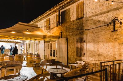 Structure en bois éclairée la nuit, avec des sphères lumineuses blanches posées sur un sol en pierre.