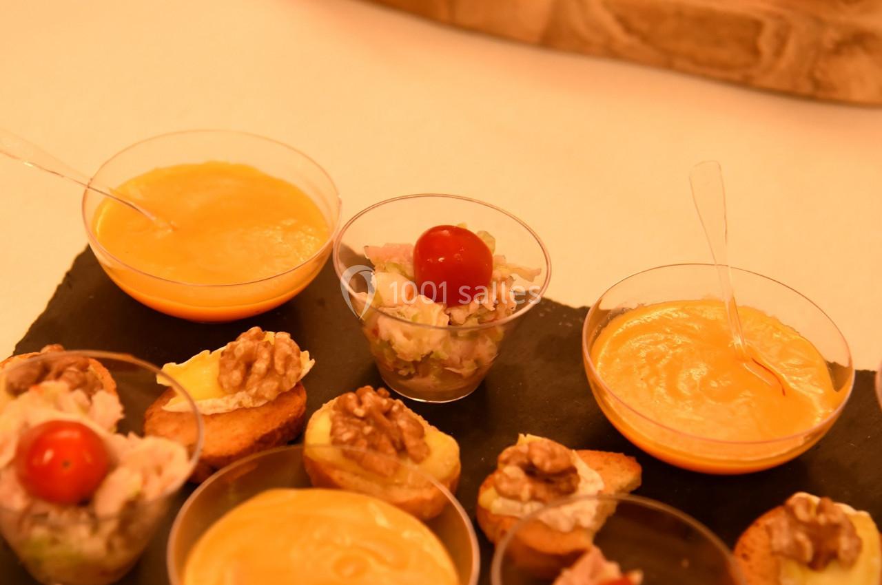 Assortiment de verrines, toasts et amuse-bouches variés présentés sur une ardoise et un plateau en bois.