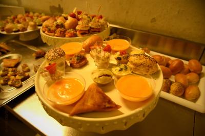 Plateau de bouchées apéritives variées comprenant samoussas, brochettes de légumes et crevettes sur toasts.