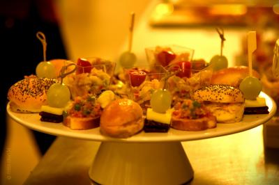 Plateau de bouchées apéritives variées comprenant samoussas, brochettes de légumes et crevettes sur toasts.