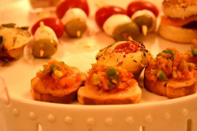 Plateau de bouchées apéritives variées comprenant samoussas, brochettes de légumes et crevettes sur toasts.