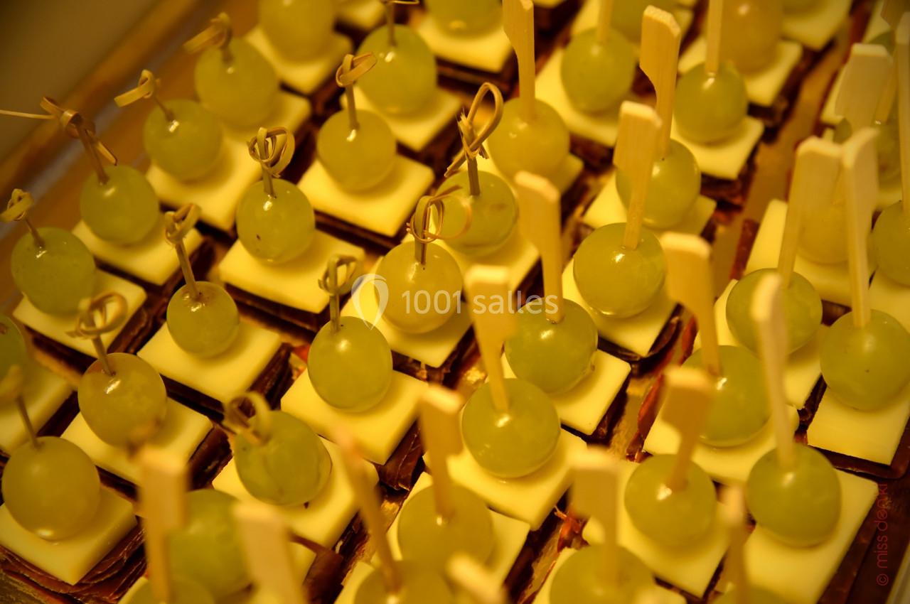 Petits amuse-bouches composés de raisins, fromage et biscuits, présentés sur des bâtonnets en bois.