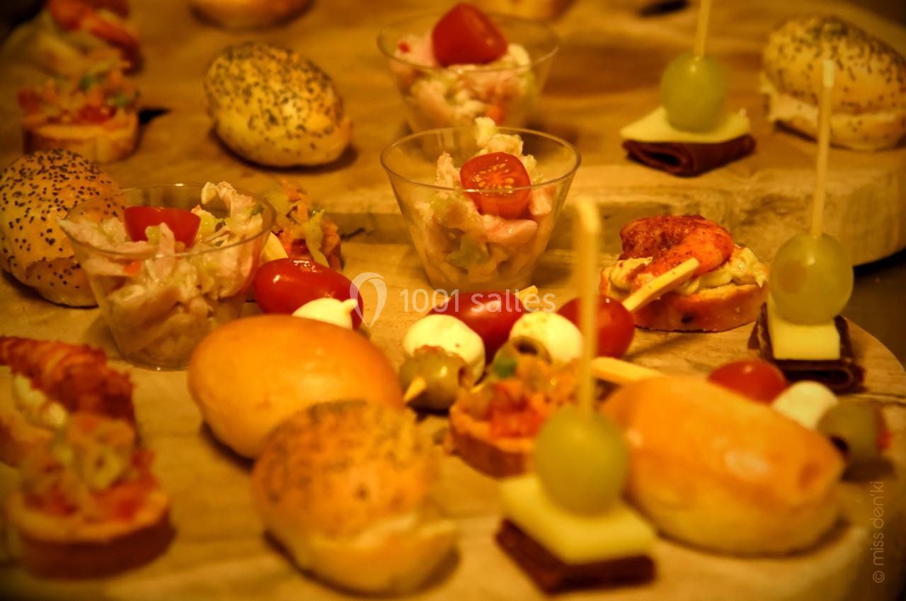 Assortiment de bouchées apéritives variées disposées sur un plateau en bois.