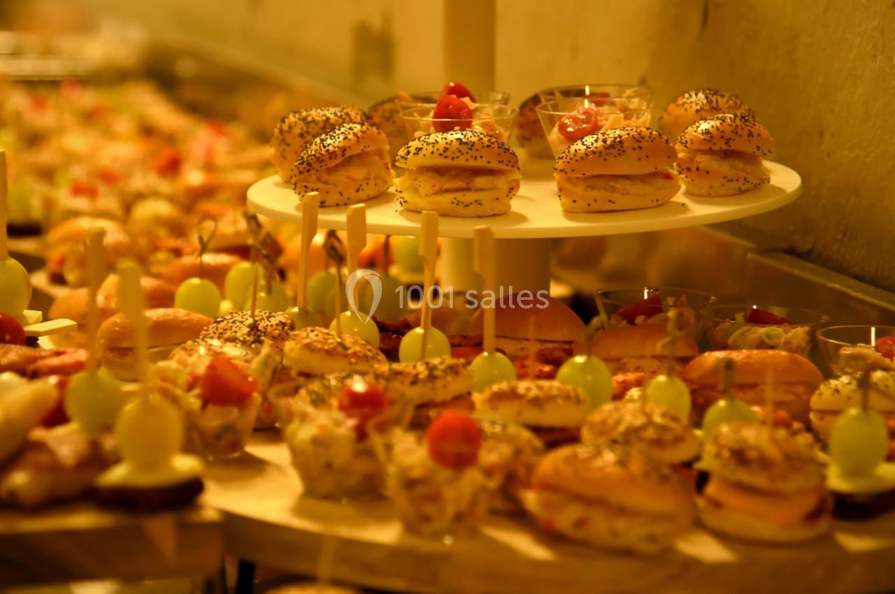 Plateaux de petits fours variés disposés sur plusieurs niveaux dans un cadre chaleureux et éclairé.