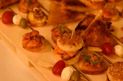 Plateau de bouchées apéritives variées comprenant samoussas, brochettes de légumes et crevettes sur toasts.