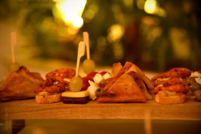 Plateau de bouchées apéritives variées comprenant samoussas, brochettes de légumes et crevettes sur toasts.