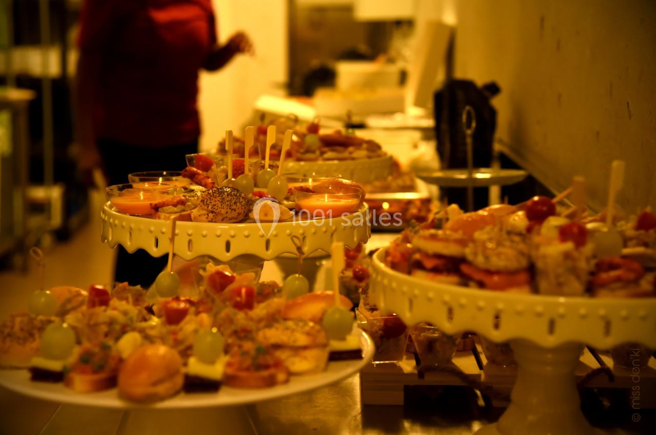 Plateaux de bouchées apéritives variées disposés sur des présentoirs dans un espace de restauration.