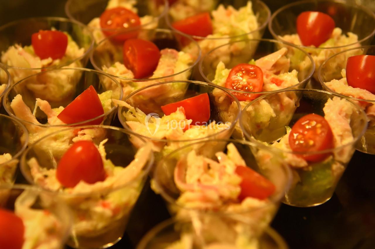 Verrines garnies de salade composée, morceaux de crabe et tomates cerises, présentées sur un plateau.