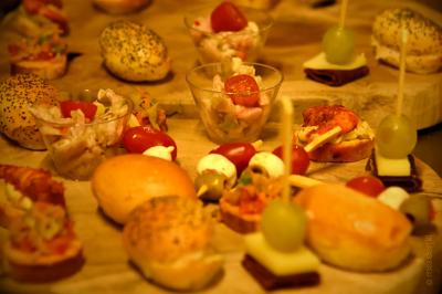 Plateau de bouchées apéritives variées comprenant samoussas, brochettes de légumes et crevettes sur toasts.