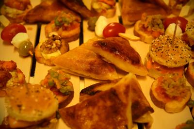 Plateau de bouchées apéritives variées comprenant samoussas, brochettes de légumes et crevettes sur toasts.